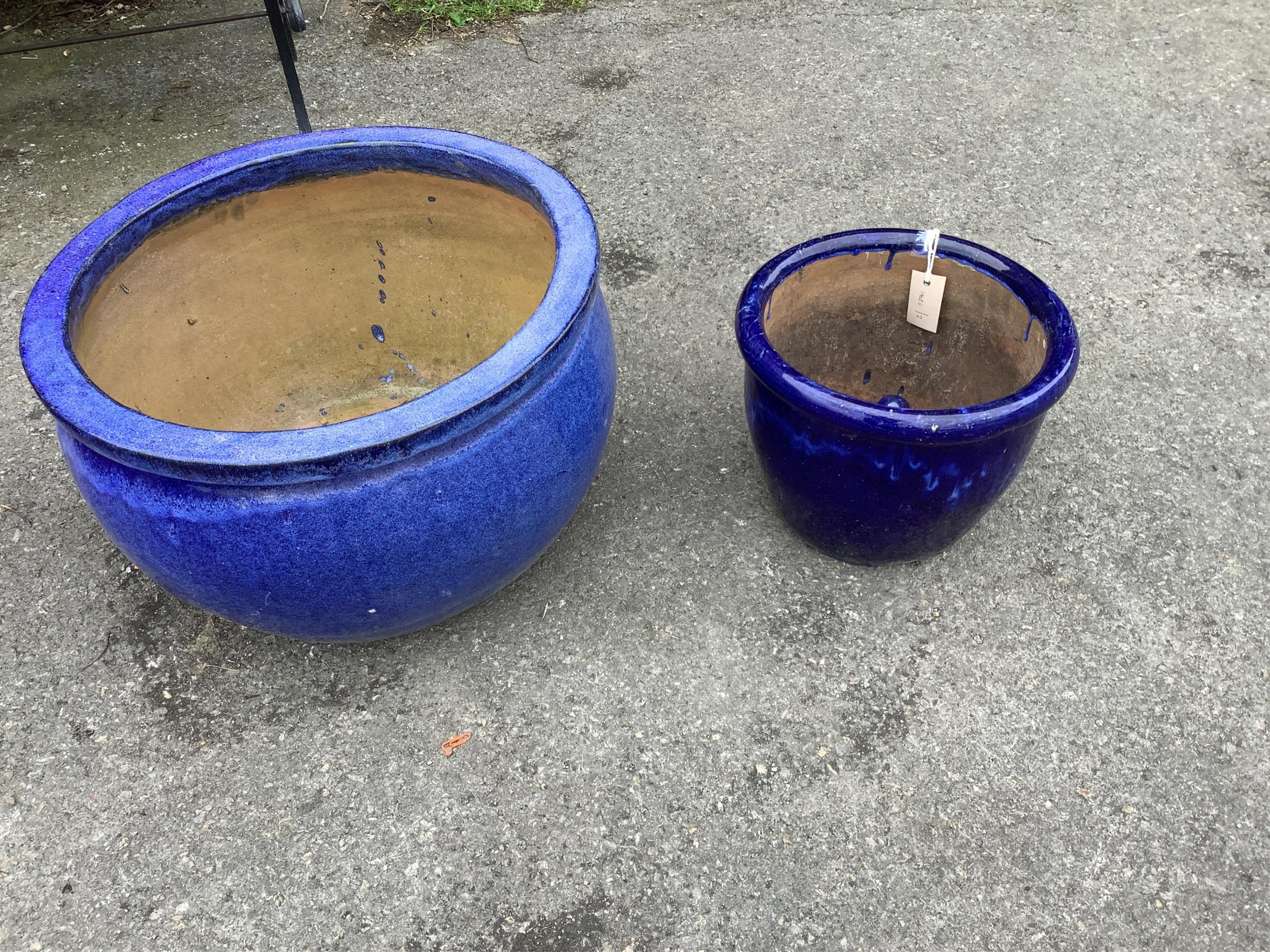 Two circular blue glazed earthenware garden planters, with detachable feet, largest diameter 51cm, height 32cm
